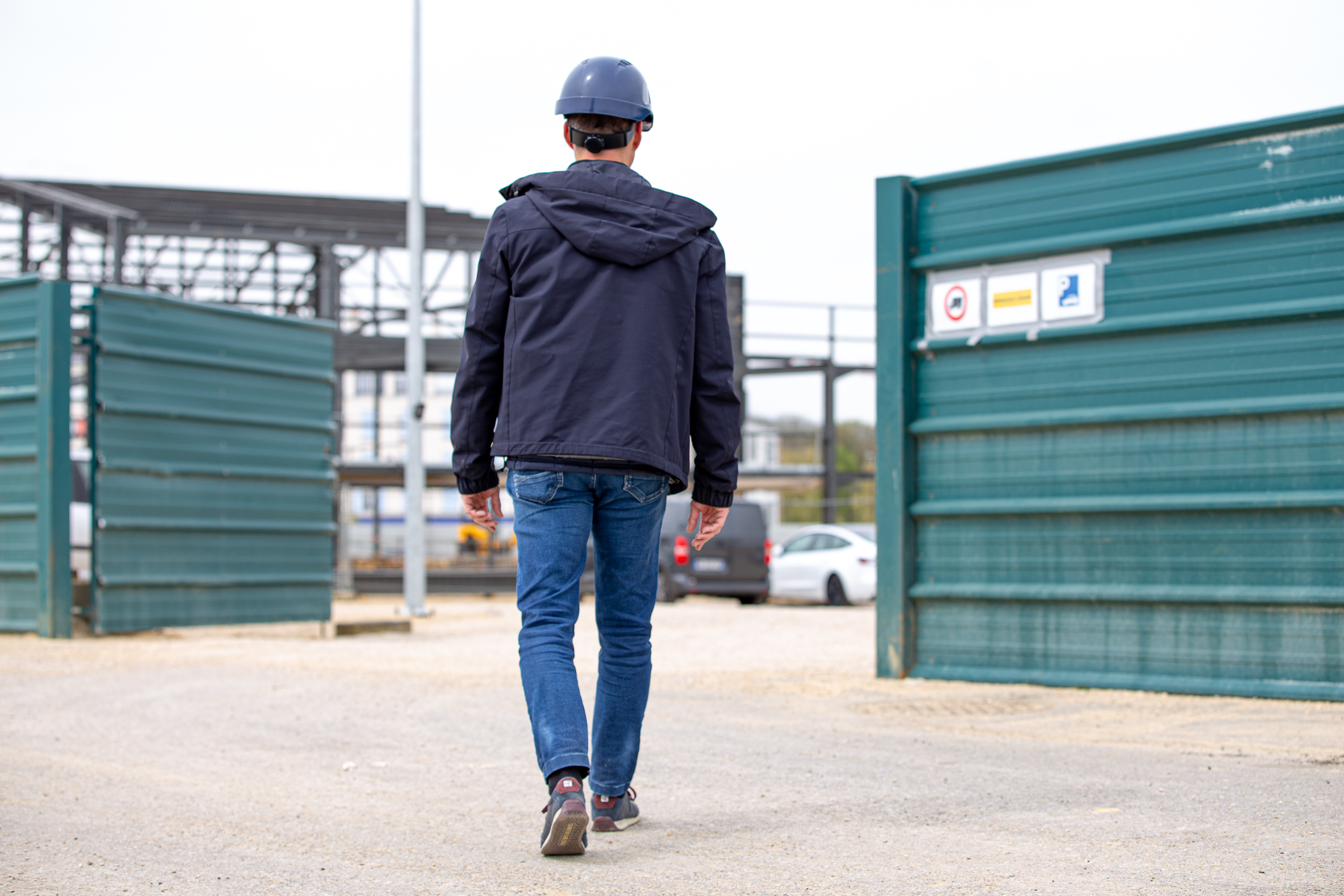 Contractant général en Seine-et-Marne (77), le fondateur d’Aedifici'hom, Nicolas DORGLER, entre sur un chantier délimité par des palissades de chantier.