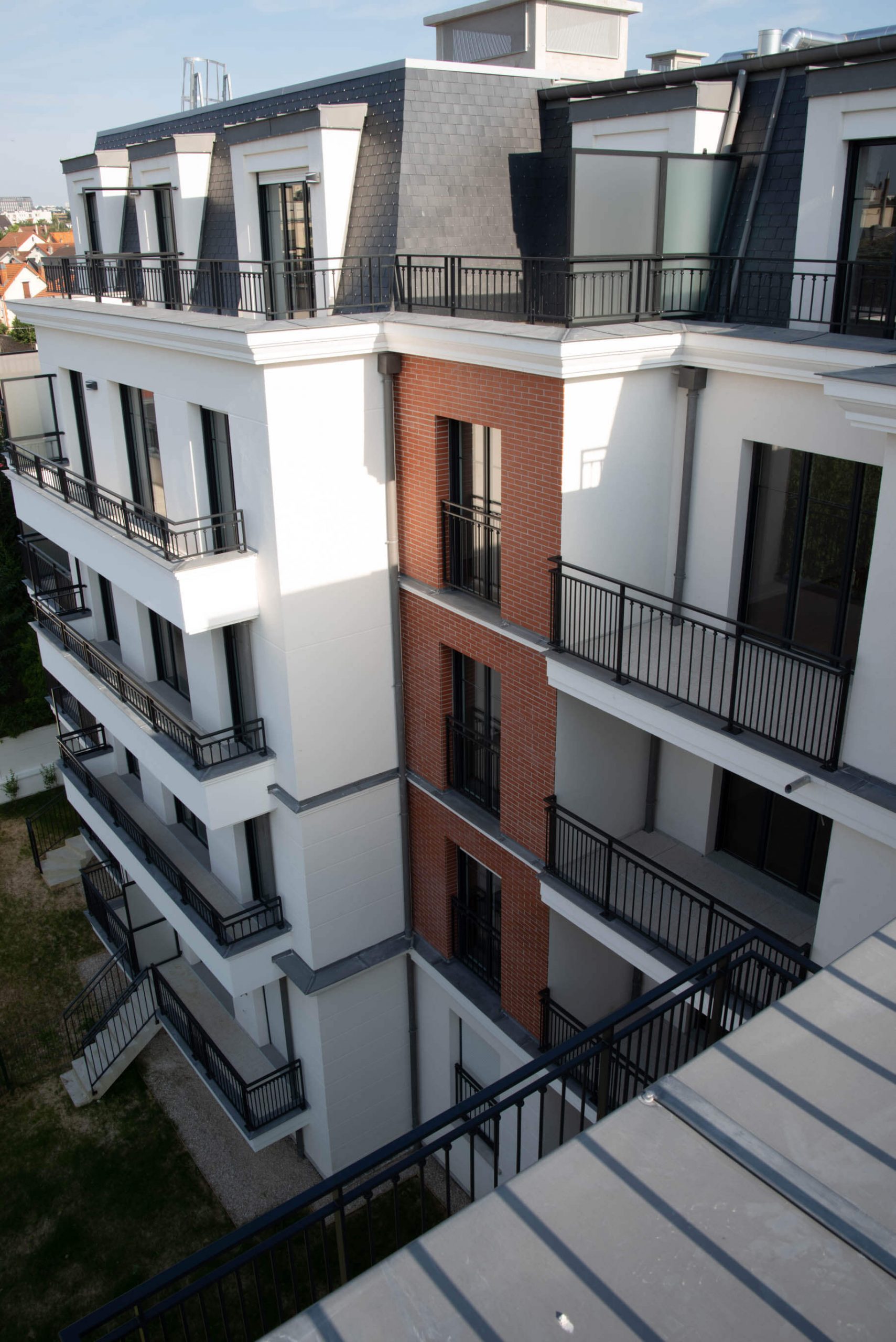 Vue en hauteur depuis le toit d’un immeuble neuf au Perreux-sur-Marne, avec 5 niveaux d’appartements et balcons extérieurs. Livré sous la responsabilité de Nicolas DORGLER, conducteur de travaux expérimenté.