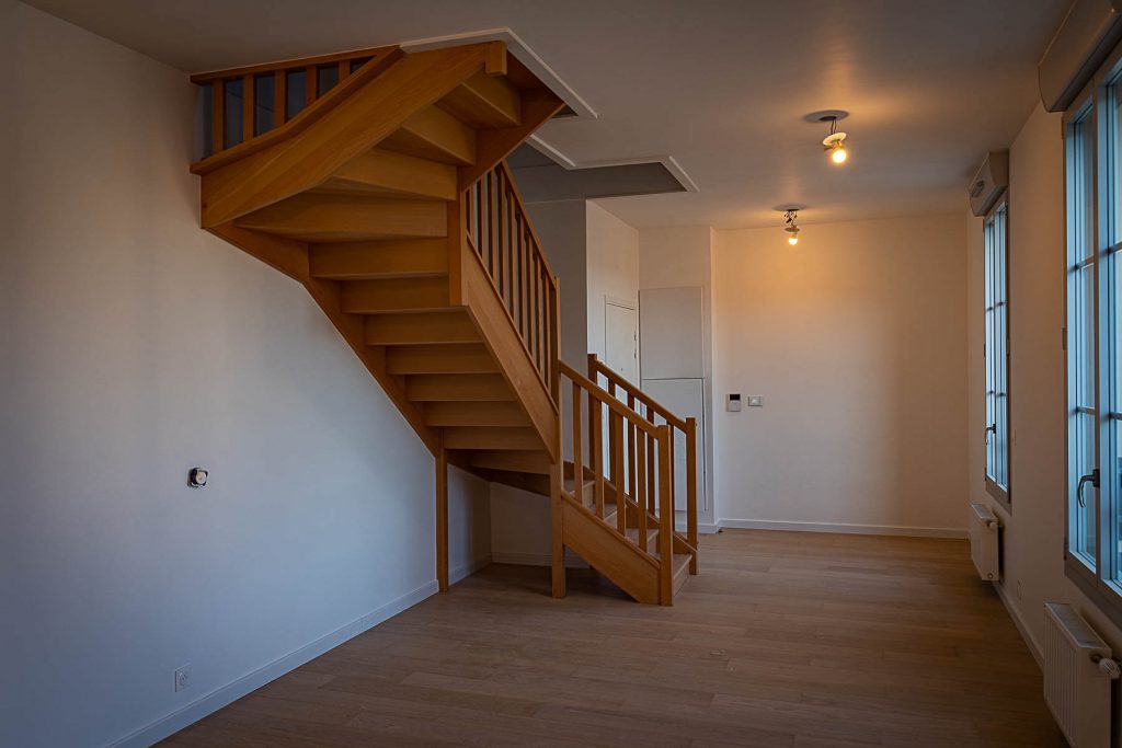 Vue intérieure d’un appartement en duplex avec escalier en bois, dans une résidence neuve à Bry-sur-Marne, livré sous la supervision de Nicolas DORGLER alors conducteur de travaux.